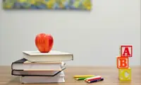 Classroom desk and study materials representing worksheets and practice pages.